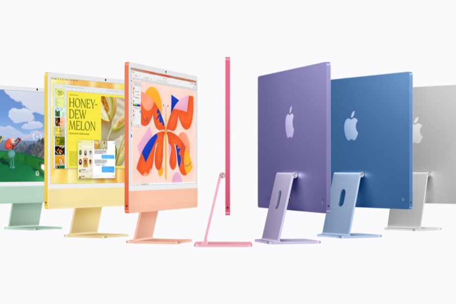 A row of seven iMacs in green, yellow, orange, pink, purple, blue and silver, some facing forward, one side-on and three seen from behind