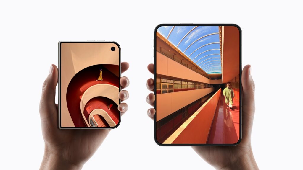 Hands holding two iPhone Duo models, one closed and one open